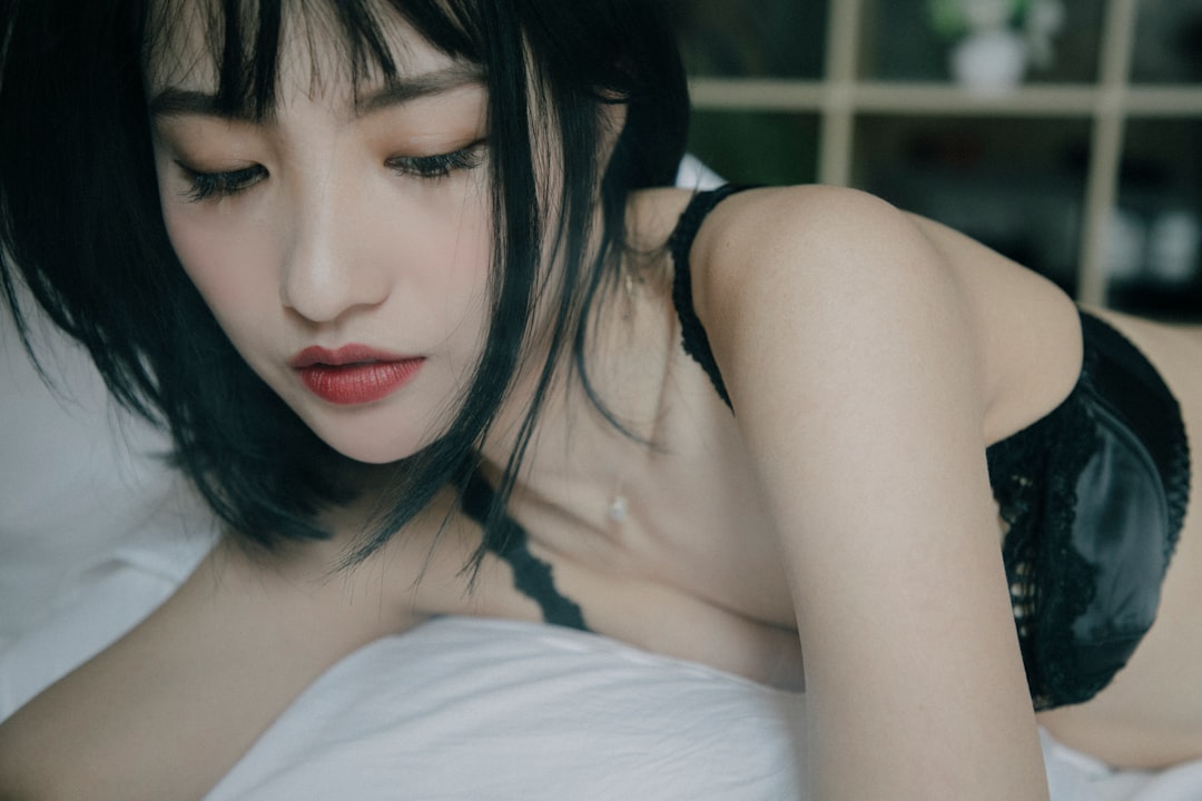 a woman laying in bed with her eyes closed
