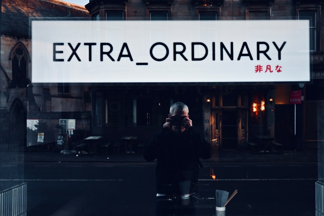 A man walking down a street past a tall building